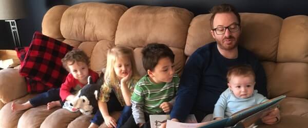 Picture of Dwayne reading to Andrew, A'zalea, and the cousins